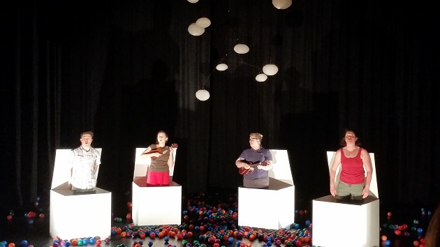 The cast of Emily Loves to Bounce performing among illuminated boxes and coloured balls